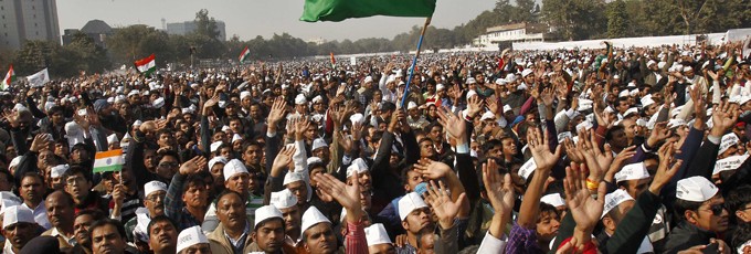 Supporters of AAP wave as they listen to a speech by their leader Kejriwal after he took an oath as new chief minister of Delhi during a swearing-in ceremony at Ramlila ground in New Delhi